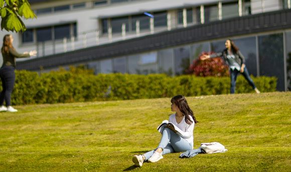 Students playing frisbee on the grass outside ҹɫֱ, Edinburgh