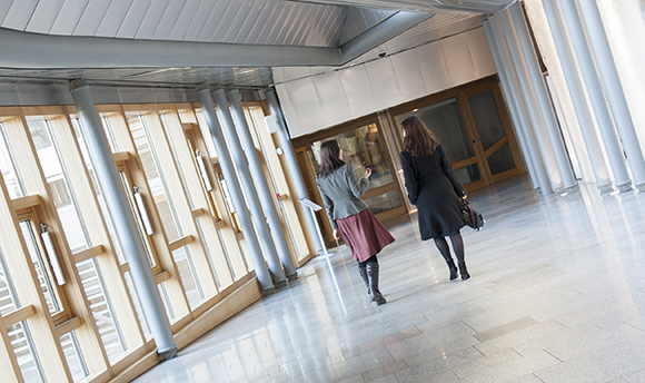 Two women walking down a corridor in ҹɫֱ hallway