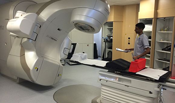 A ҹɫֱ student standing beside a Radiotherapy machine